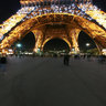 At the foot of illuminated Eiffel Tower, Paris